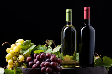 Obraz na płótnie Canvas Wine bottles and a glass on a barrel