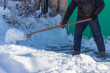 Naklejka premium Man cleans the road from snow in winter