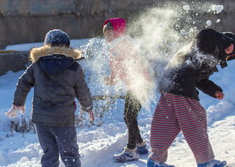 Children play with snow in nature in winter
