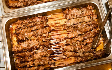 silver plates filled with plenty souvlaki sticks.