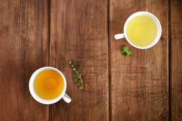 Herbal tea, shot from above on a dark wooden background with herbs and copyspace
