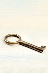 A photo of a vintage key on a light background with copyspace