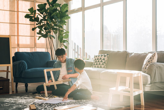 Father and son working on carpentry at home