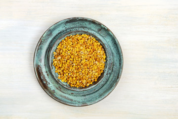 Bee pollen, shot from the top on a light background with copy space