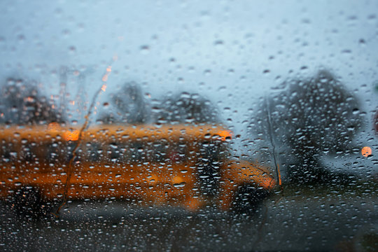 A School Bus Driving By A Rainy Window