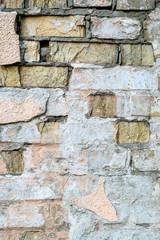 Scratched light brick wall. Abstract background. Outdoors. Vertical.