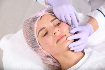 Fototapeta na wymiar Woman undergoing face biorevitalization procedure in salon. Cosmetic treatment