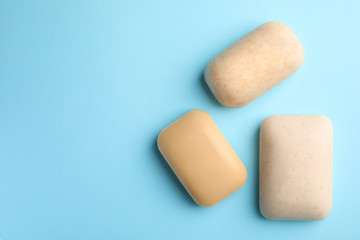 Different soap bars and space for text on color background, top view