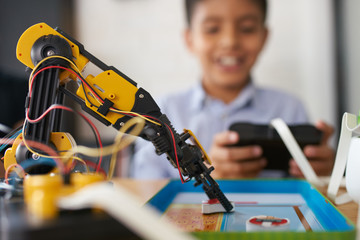 Closeup of a robot with a boy in the background