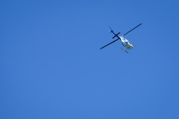 Fototapeta na wymiar Helicopter in flight from below against blue sky. Add your own text.