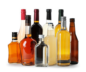 Bottles with different alcoholic drinks on white background