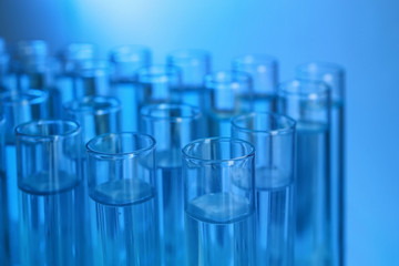 Test tubes with liquid against color background, closeup. Laboratory analysis