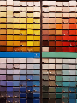Colorful paint swatches ordered from light to dark, and in color categories, at the hardware store