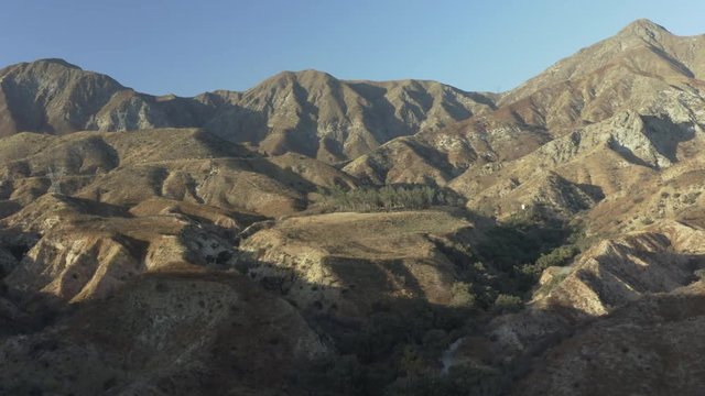 Aerial descend of a barren mountainous landscape in the desert.