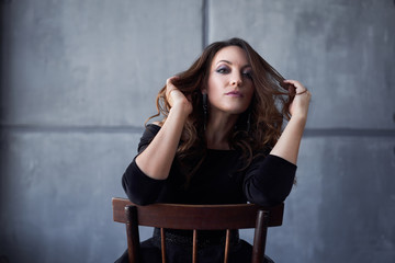 Beautiful girl with makeup and hairdo in a black dress