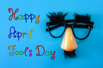 Happy april fool's day and funny pranks concept with a pair of comical glasses with bushy eyebrows...