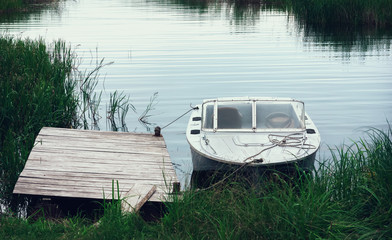 Motorboat At The Pier Among The reeds In A River Bay