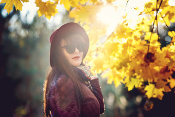 Outdoor close up portrait big size model beautiful brunette girl with hat and sunglass looking at camera  in autumn forest as background