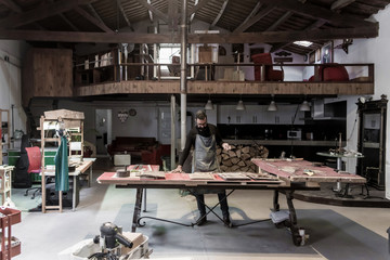 Young guitar luthier working in his workshop
