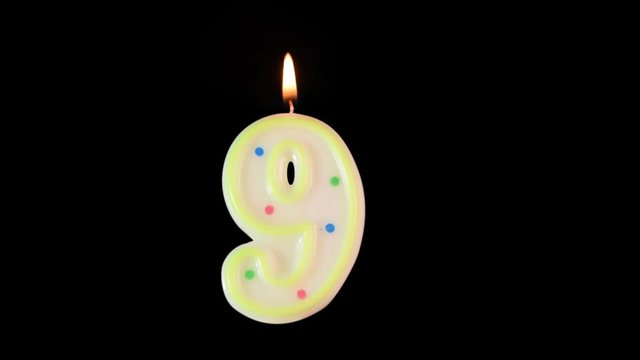 Wax candle in shape of number 9 burns. A nice addition to your birthday video. Made with alpha matte - background is transparent.