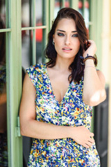 Young woman with blue eyes standing next to beautiful door.