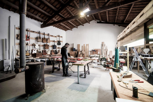 Young guitar luthier working in his workshop
