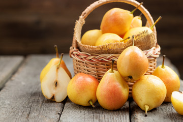 Fresh pears  in a basket on wooden table.