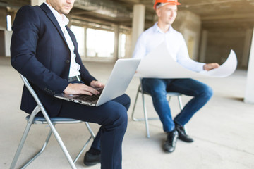 men engineers builders working at the table with a laptop, business negotiations at the...