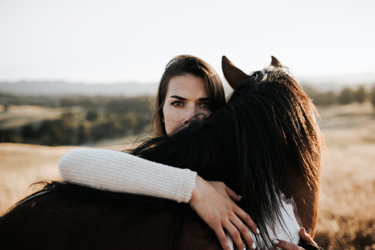 Girl hugging horse neck