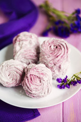 pink fruit marshmallow on a plate on a wooden background
