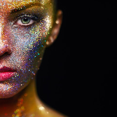 Portrait of Beautiful Woman with Sparkles on her Face. Girl with Art Make-Up in Color Light. Fashion Model with Colorful Makeup