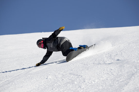 A snowboarder on slope in ski field