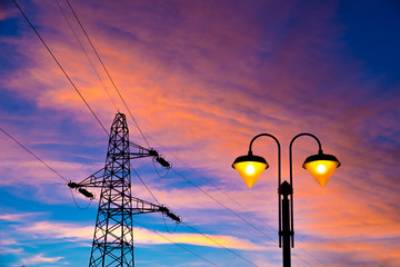 electricity pylon and streetlamp at sunset
