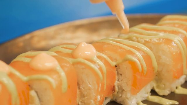 Close-up of professional chef's hands in black gloves making sushi and rolls in a restaurant kitchen. Japanese traditional food. Preparation process. step by step