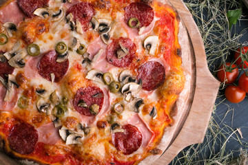 Pizza with ham and mushrooms on wooden background