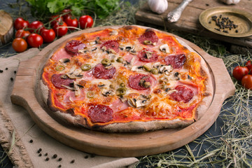 Pizza with ham and mushrooms on wooden background