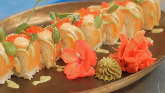 Close-up of professional chef's hands in black gloves making sushi and rolls in a restaurant kitchen. Japanese traditional food. Preparation process. step by step