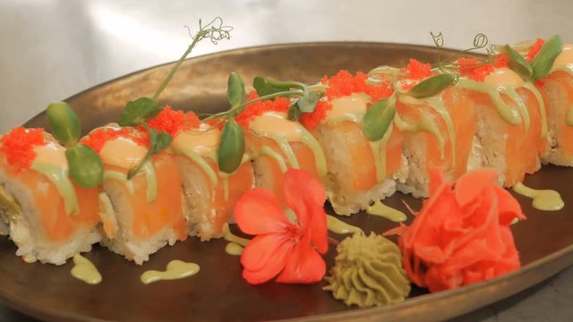 Close-up of professional chef's hands in black gloves making sushi and rolls in a restaurant kitchen. Japanese traditional food. Preparation process. step by step