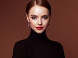 Beautiful Young Woman with Clean Fresh Skin. Perfect Makeup. Beauty Fashion. Red Lips. Cosmetic Eyeshadow. Smooth Hair. Girl in Black Turtleneck