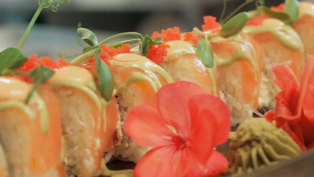 Close-up of professional chef's hands in black gloves making sushi and rolls in a restaurant kitchen. Japanese traditional food. Preparation process. step by step