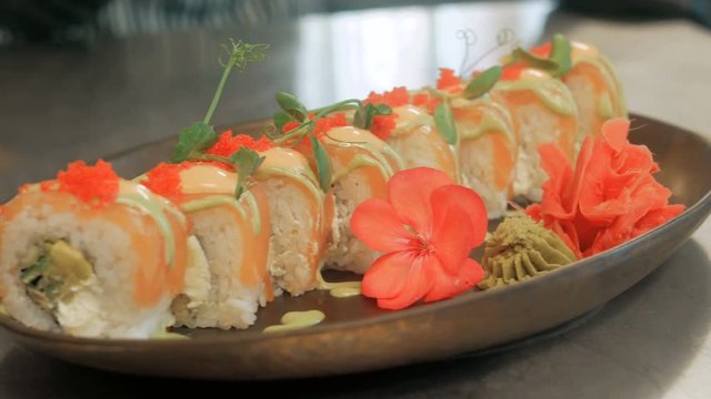Close-up of professional chef's hands in black gloves making sushi and rolls in a restaurant kitchen. Japanese traditional food. Preparation process. step by step