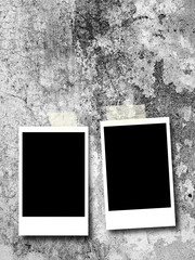 Two blank rectangular instant photo frames on gray weathered concrete wall background