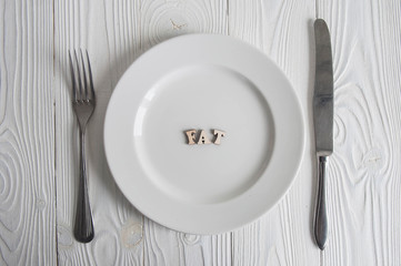 Words on white empty plate from wooden letters: Diet, anorexia and hunger concept. 