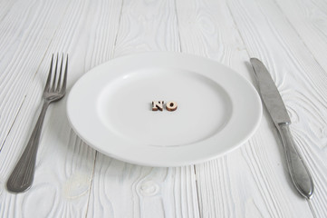 Words on white empty plate from wooden letters: Diet, anorexia and hunger concept. 