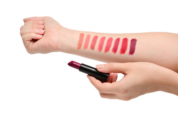 Lipstick swatches on woman hand isolated on white background.