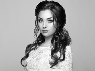 Brunette Woman with Long and shiny Curly Hair. Beautiful Model Lady with Curly Hairstyle. Care and Beauty Hair products. Care and Beauty of Hair