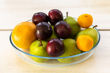 Bowl of fruit on a wooden table from a side view