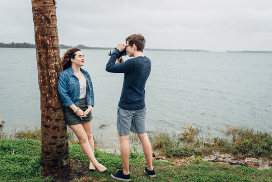 Boy filming her girlfriend with a vintage 8mm film camera