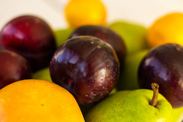 Close up of a plum lying on a top of fresh fruit