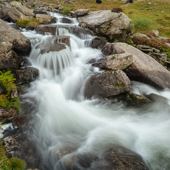 Moody landscape image of river flowing down mountain range near Llyn Ogwen and Llyn Idwal in Snowdonia in Autumn